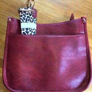Burgundy multi pocket crossbody purse with leopard strap.
